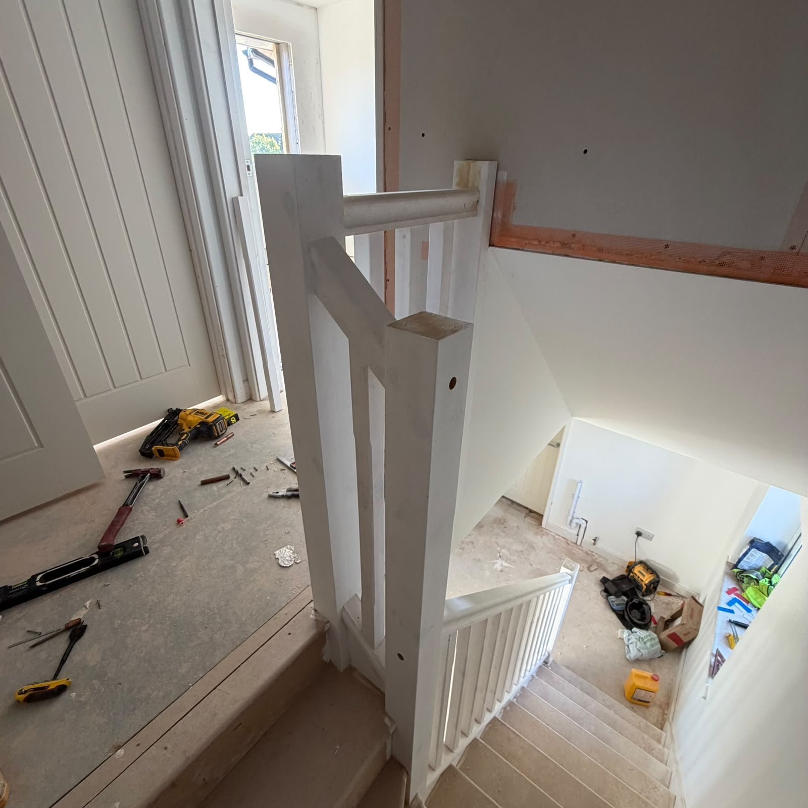 Stair balustrade with a timber handrail and white spindles